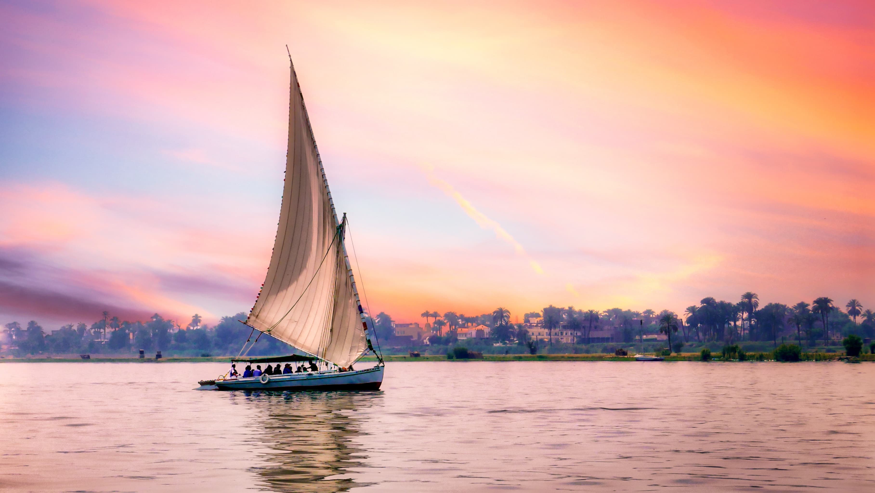 Peaceful Nile at sunset with traditional boat